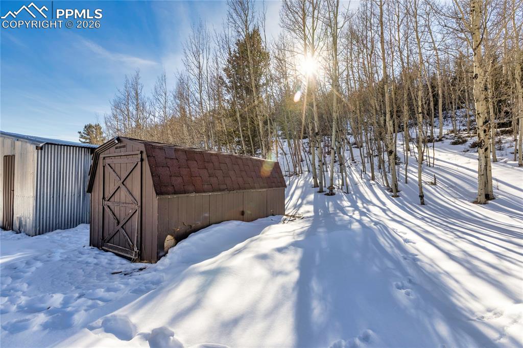 Image 44 of 46: Snowy yard with a storage shed