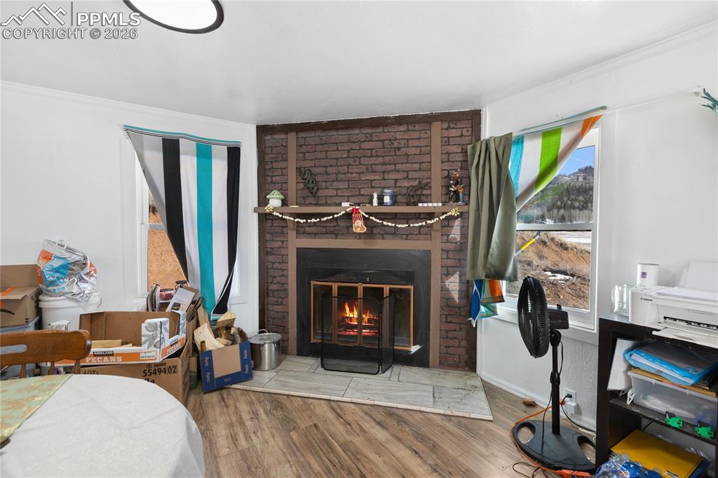 Image 5 of 37: The dining area with wood finished floors and a wood fireplace!