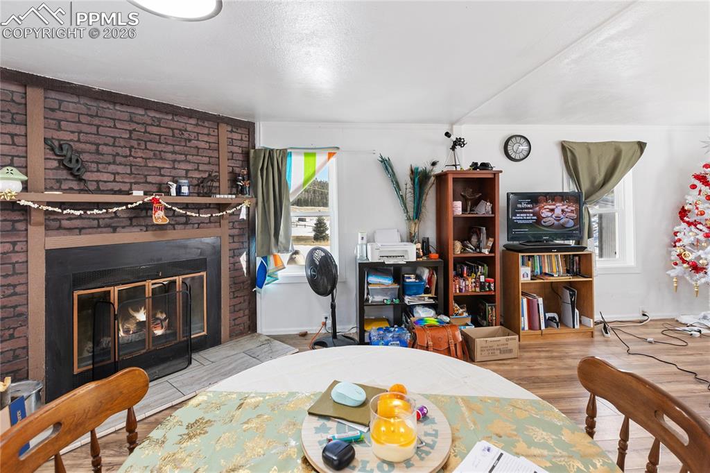 Image 6 of 37: The dining area featuring a fireplace and wood finished floors!