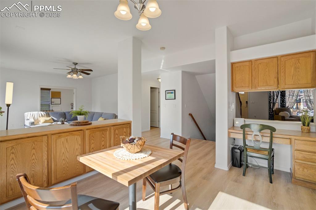Image 10 of 50: Dining space with light wood-type flooring, a desk, and ceiling fan