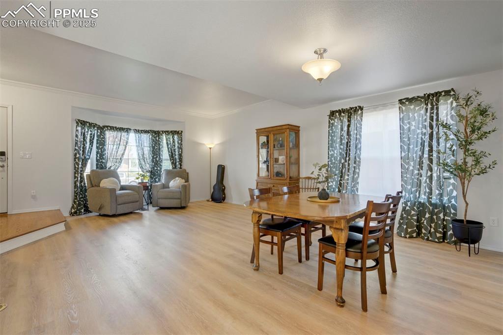 Image 14 of 50: Dining room featuring light wood-style flooring and crown molding