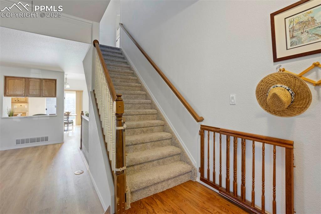 Image 23 of 50: Staircase featuring wood finished floors and crown molding