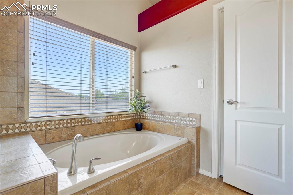 Image 29 of 50: Full bath featuring a bath and light tile patterned floors