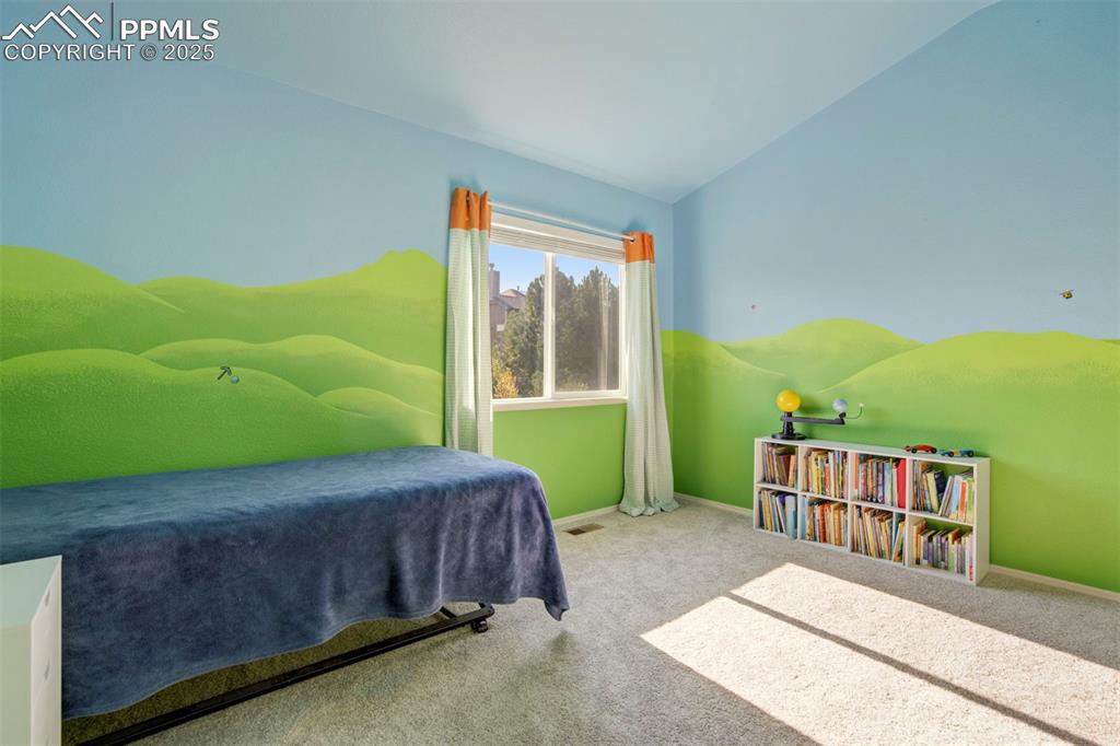 Image 34 of 50: Carpeted bedroom with baseboards and vaulted ceiling