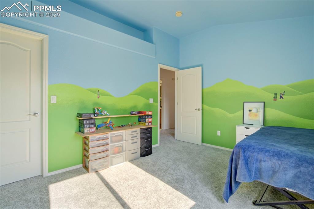 Image 35 of 50: Bedroom with light carpet and vaulted ceiling