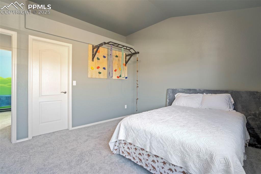 Image 37 of 50: Bedroom with carpet and vaulted ceiling