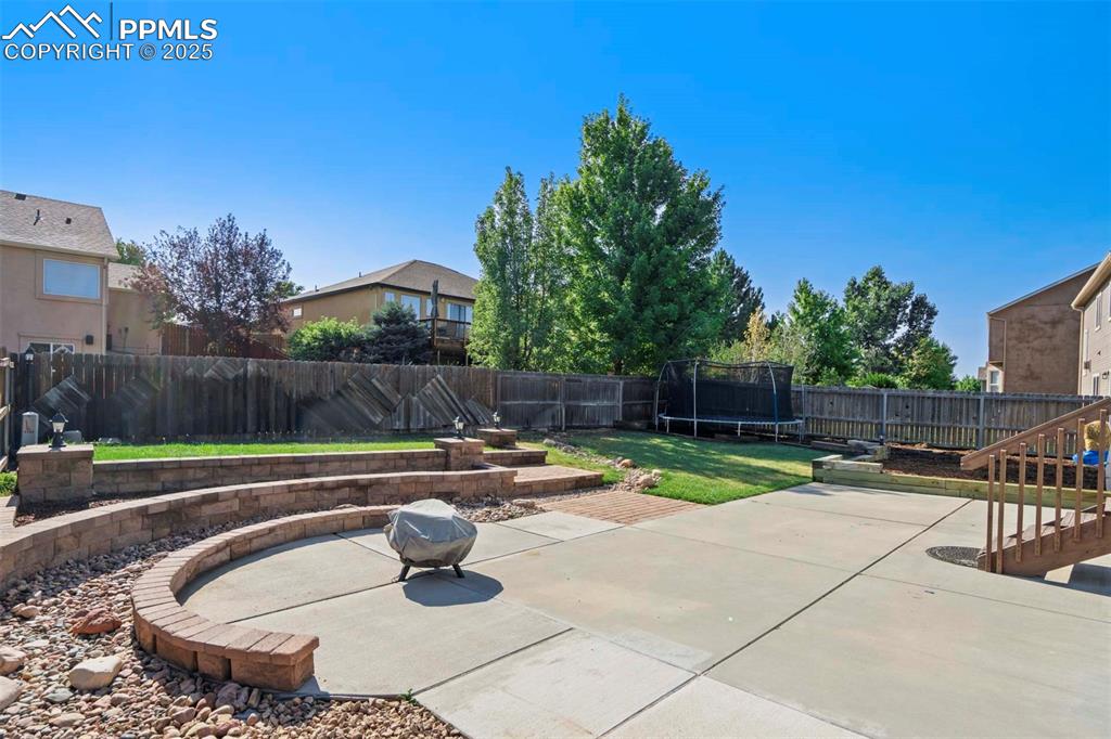 Image 44 of 50: Fenced backyard featuring a patio and a trampoline