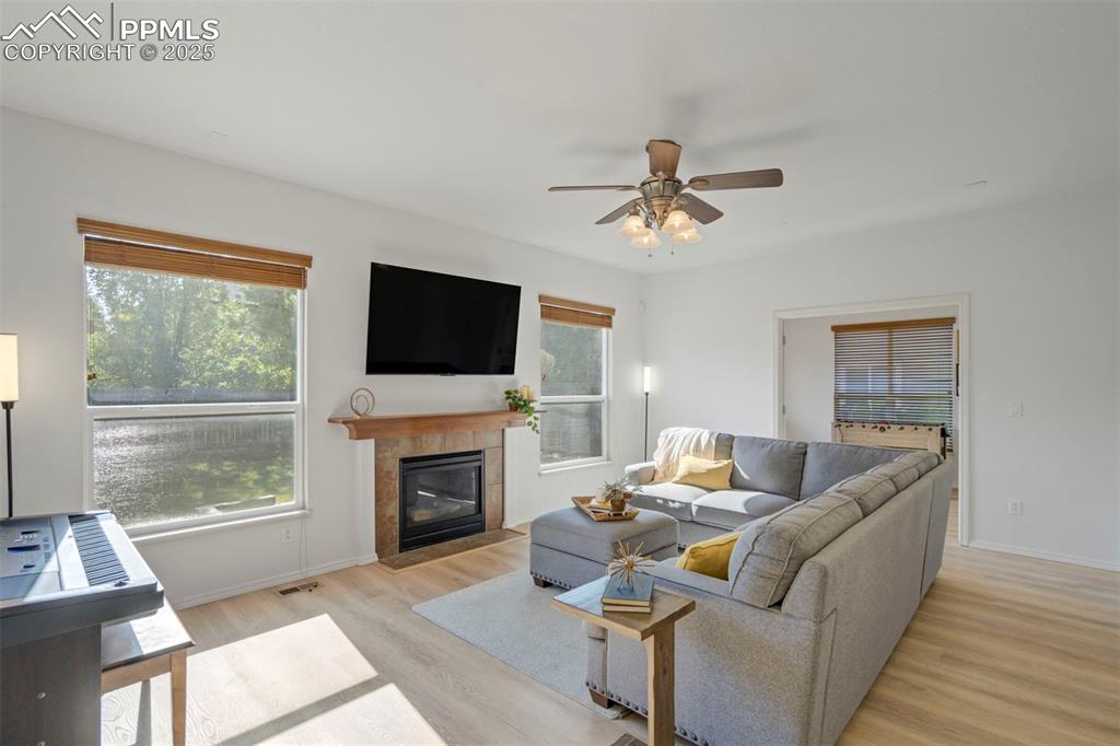 Image 6 of 50: Living area featuring a fireplace, light wood-style flooring, and a ceiling