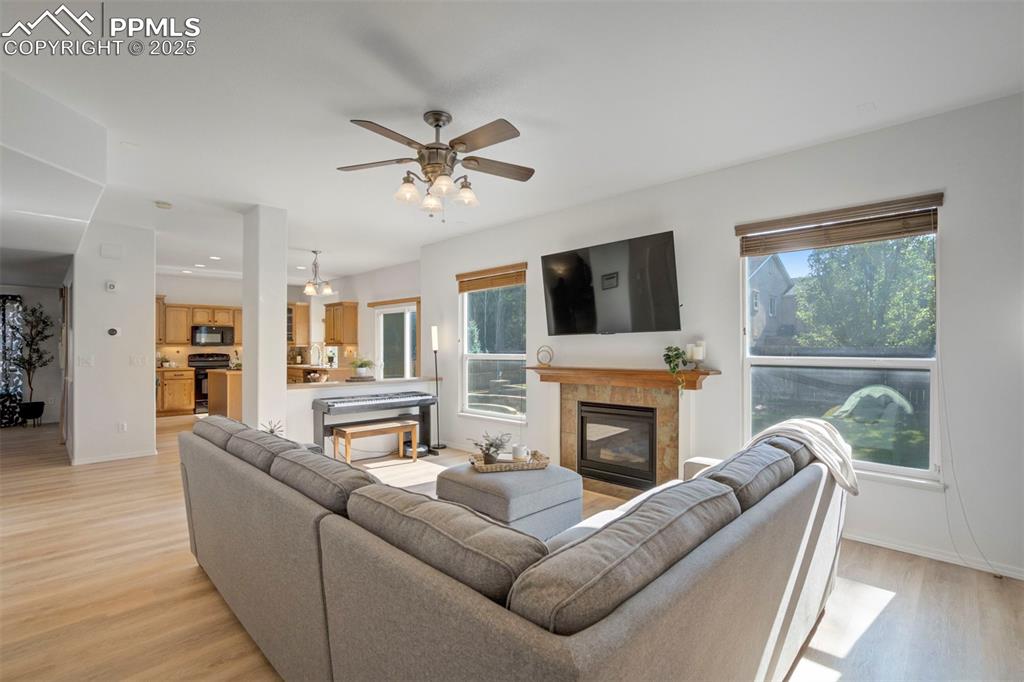Image 8 of 50: Living area featuring a fireplace, light wood-type flooring, and a ceiling
