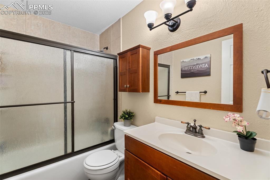 Image 12 of 23: Updated bath with full tub and modern vanity.