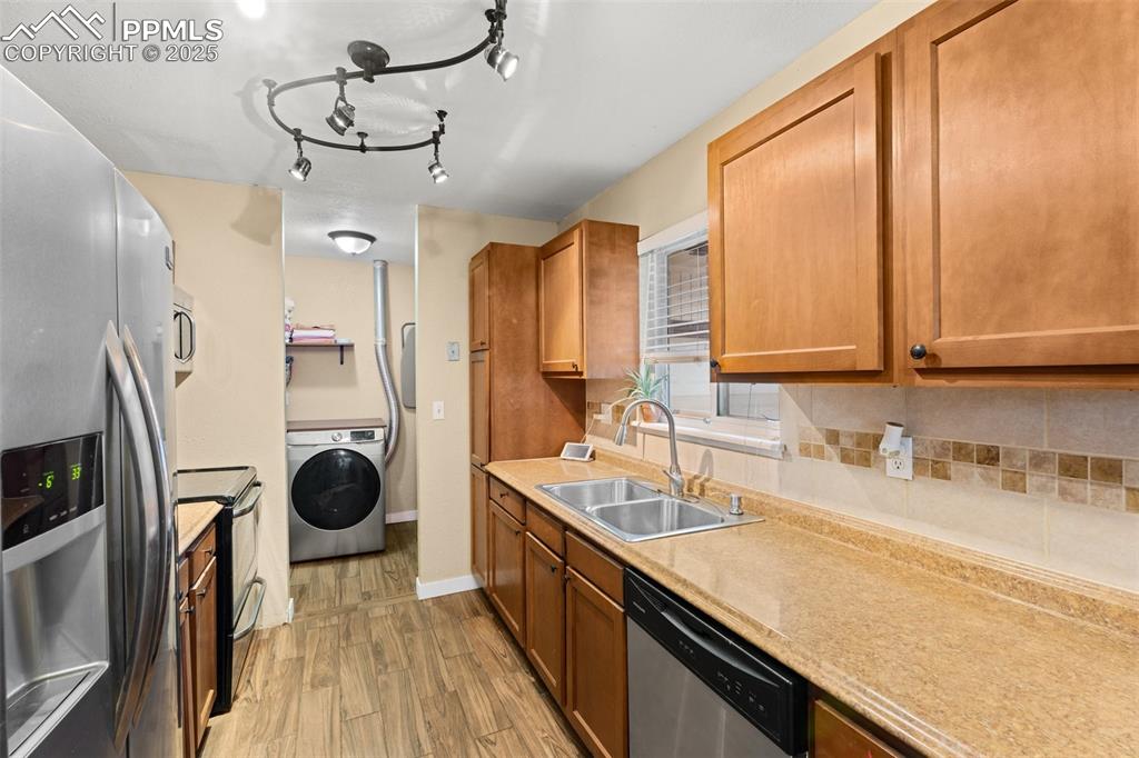 Image 15 of 23: Galley kitchen with ample cabinets and updated lighting.
