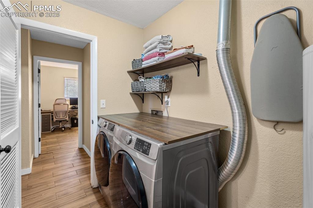 Image 19 of 23: Laundry area with storage and backyard access.