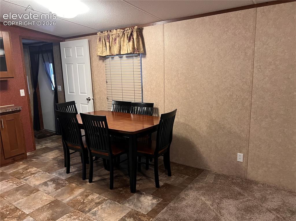 Image 10 of 24: Distinctive wall paneling, tile-finish flooring, and a flush-mount overhead