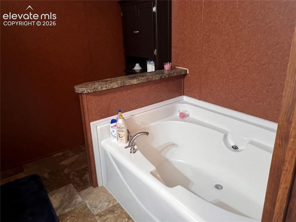 Image 12 of 16: White built-in soaking tub with chrome faucet and fixtures