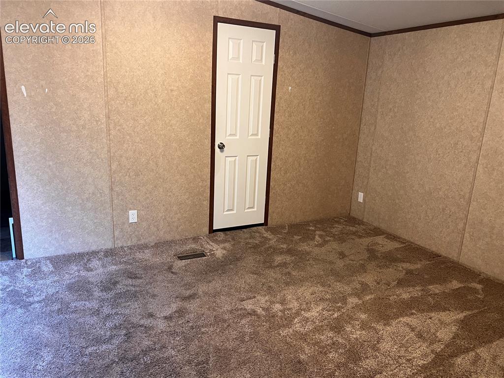 Image 19 of 24: Textured wall panels with dark trim, neutral tone carpeting, and a white pa