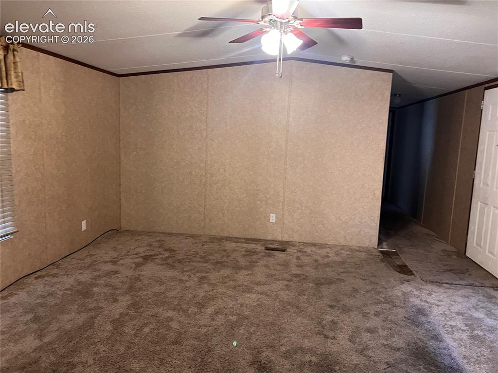 Image 22 of 24: Wall-to-wall carpeting, paneled walls, and a ceiling fan with integrated li