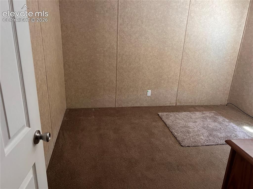 Image 24 of 24: Brown carpeted flooring and paneled walls