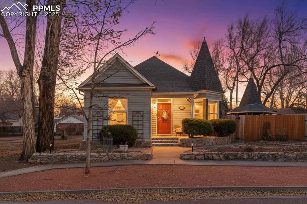 Caption: View of front of property featuring a shingled roof