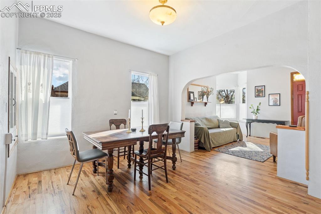 Image 10 of 37: Dining room with arched walkways and light wood-type flooring