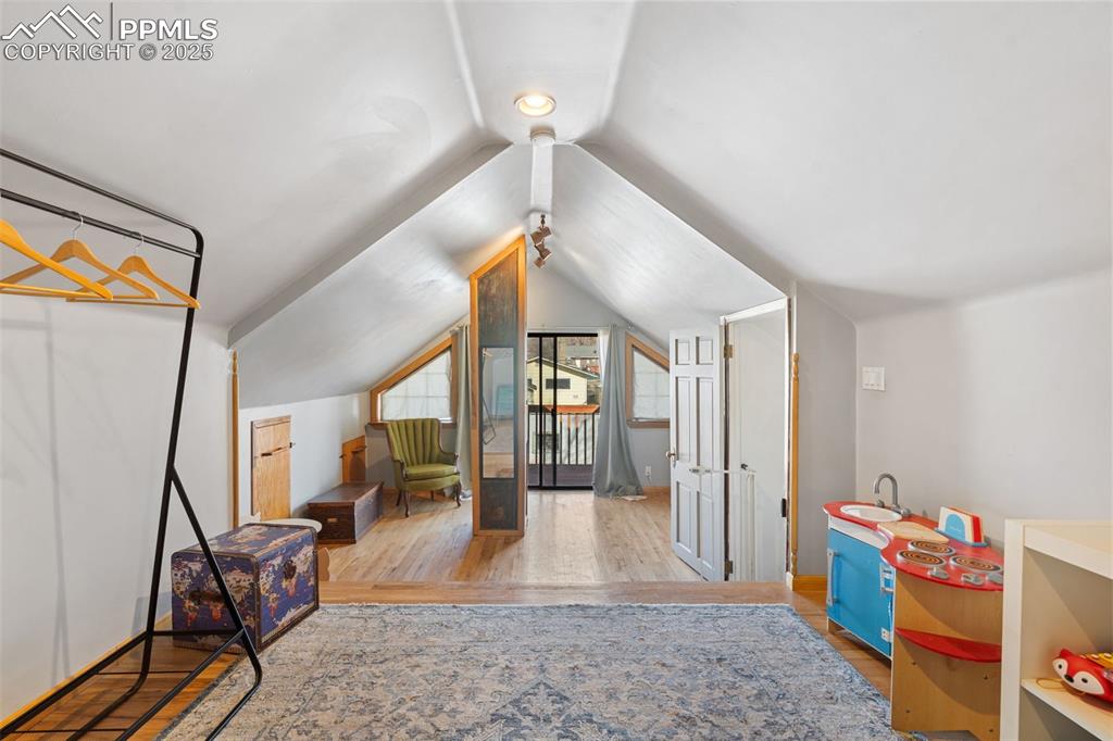Image 24 of 37: Game room with light wood finished floors and lofted ceiling