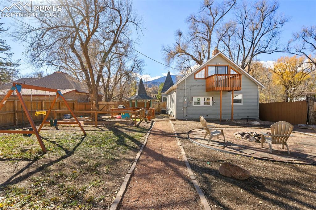 Image 30 of 37: Back of property featuring a fenced backyard, a patio, an outdoor fire pit,