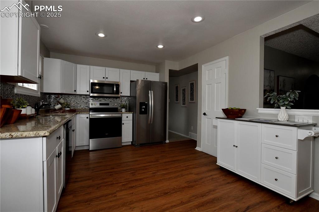 Image 13 of 36: Kitchen with appliances with stainless steel finishes, decorative backsplas