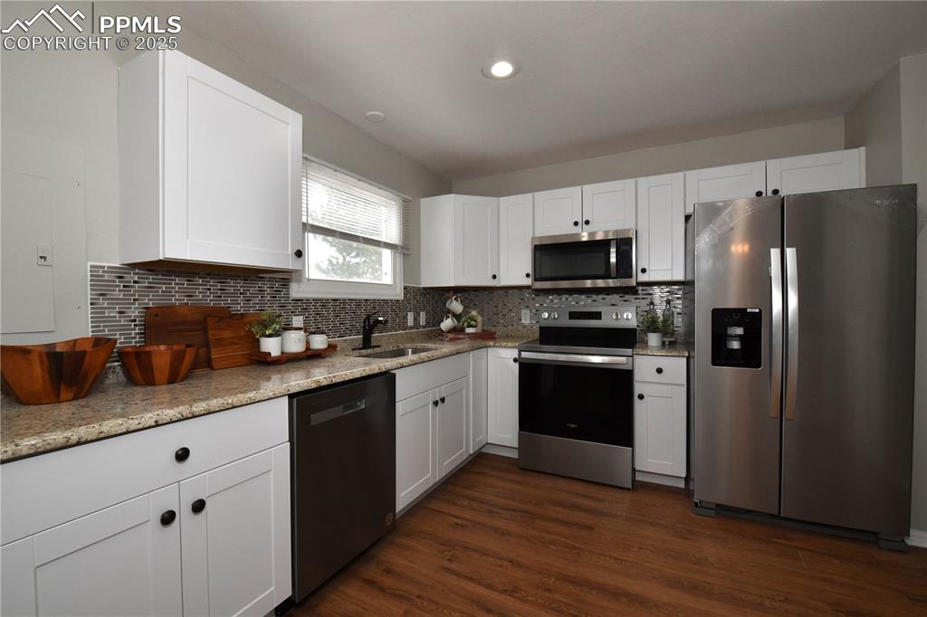 Image 15 of 36: Kitchen featuring appliances with stainless steel finishes, dark wood-type