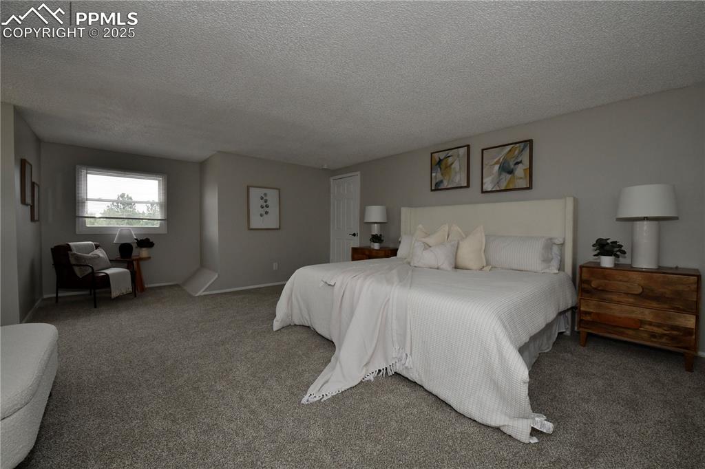 Image 19 of 36: Bedroom with a textured ceiling and carpet floors