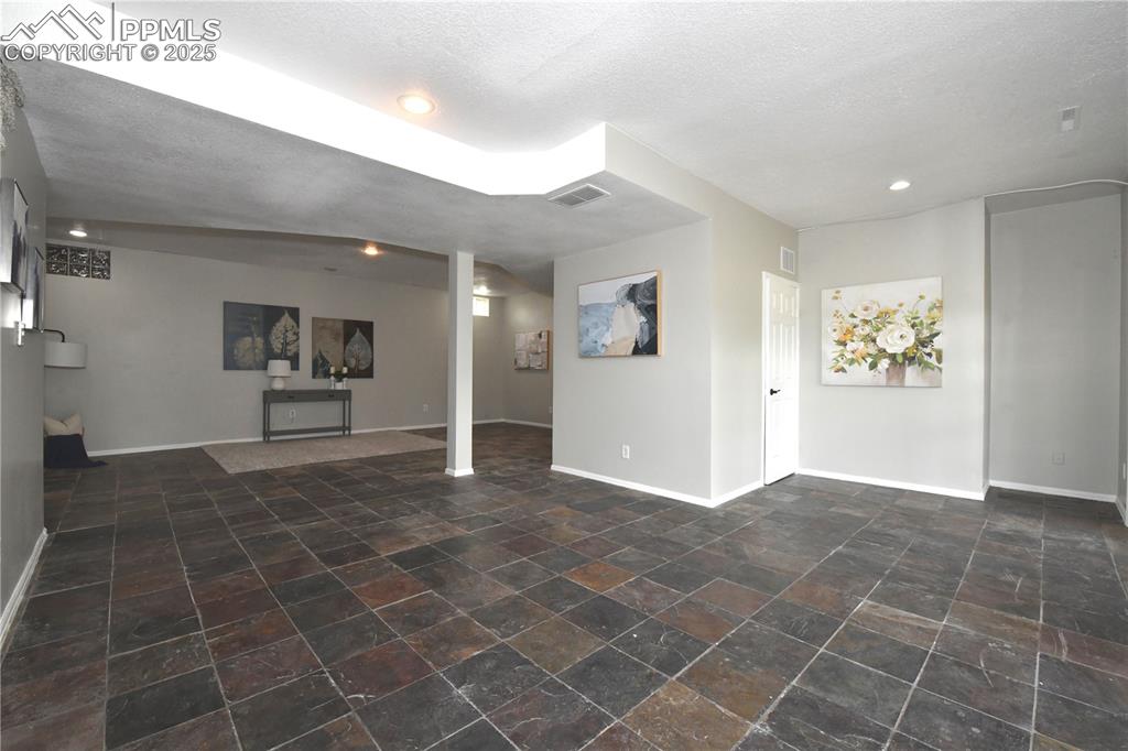 Image 21 of 36: Unfurnished living room featuring recessed lighting, stone finish flooring,