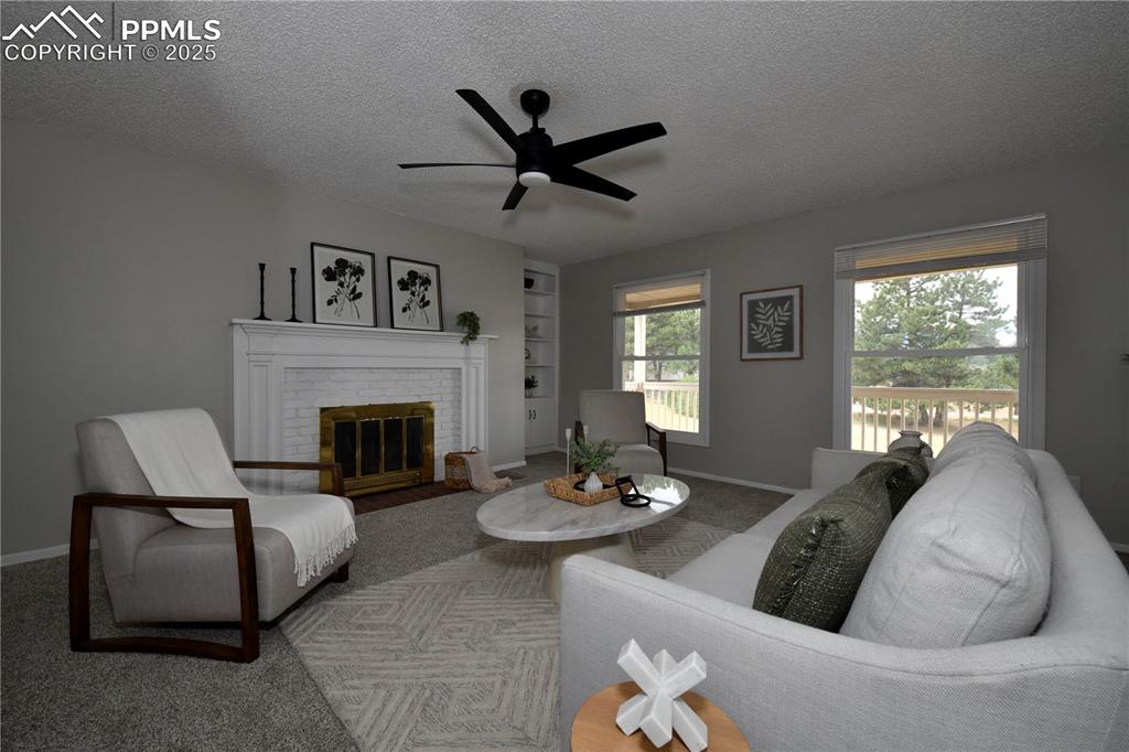 Image 3 of 36: Carpeted living room with a textured ceiling, a ceiling fan, a brick firepl