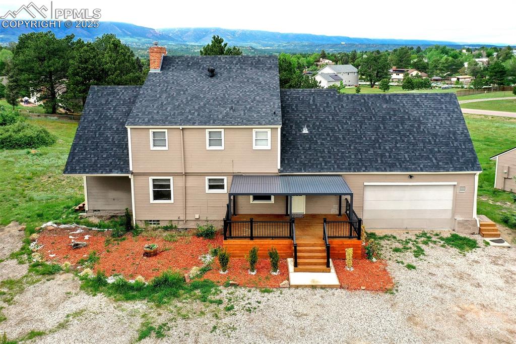 Image 33 of 36: View of front of house featuring a chimney, a garage, roof with shingles, a