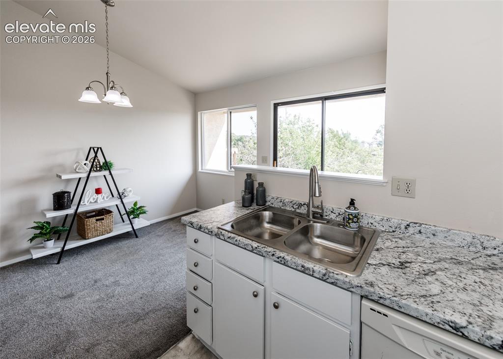 Image 13 of 36: Kitchen area featuring a double basin stainless steel sink, granite-pattern