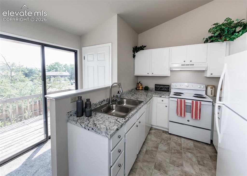 Image 14 of 36: Kitchen featuring white cabinetry, a dual basin stainless steel sink, light