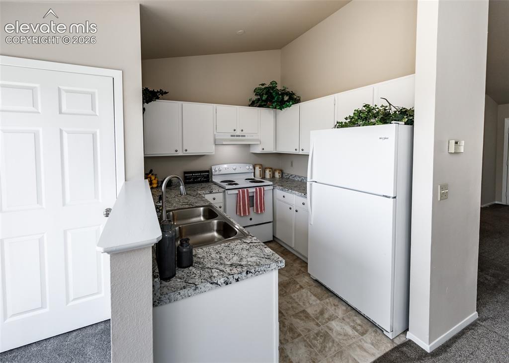 Image 15 of 36: Kitchen featuring white cabinetry, white appliances, a double basin sink, a