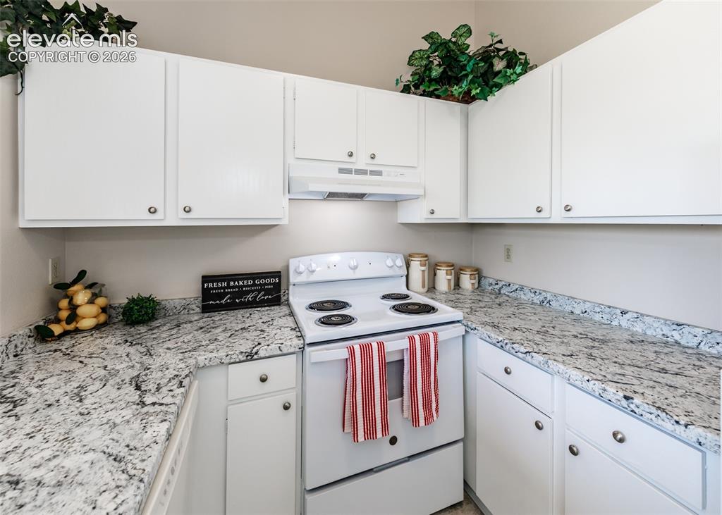 Image 16 of 36: White cabinetry with silver hardware, speckled stone-finish countertops, wh