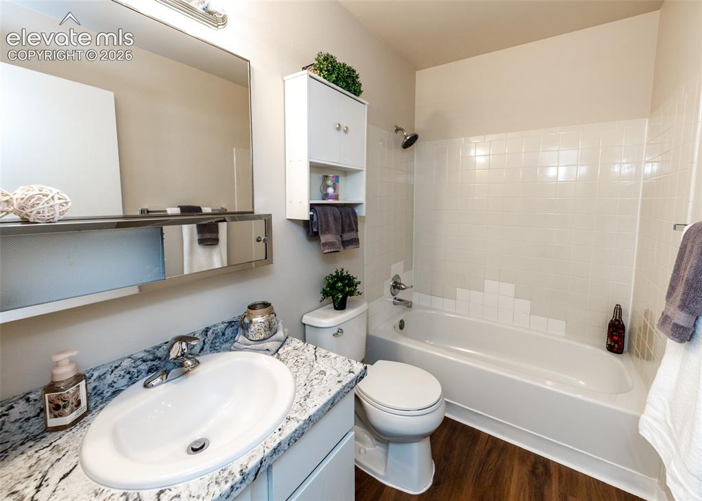 Image 27 of 36: Bathroom featuring a white vanity with an oval basin sink, a speckled count