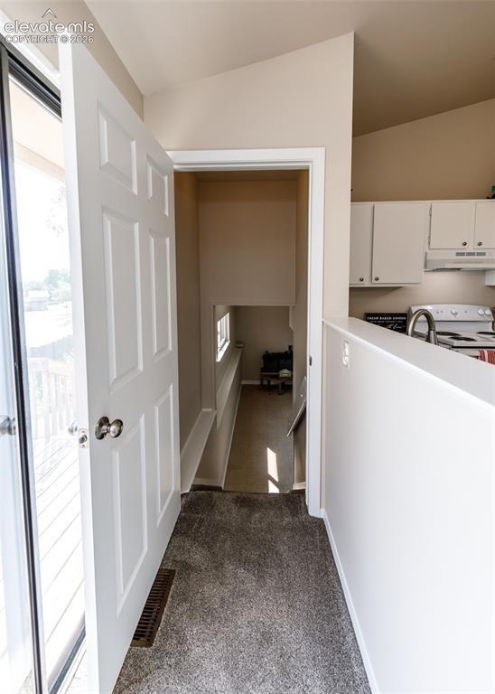 Image 30 of 36: Neutral tone wall paint, vaulted ceiling, white interior doors, gray carpet