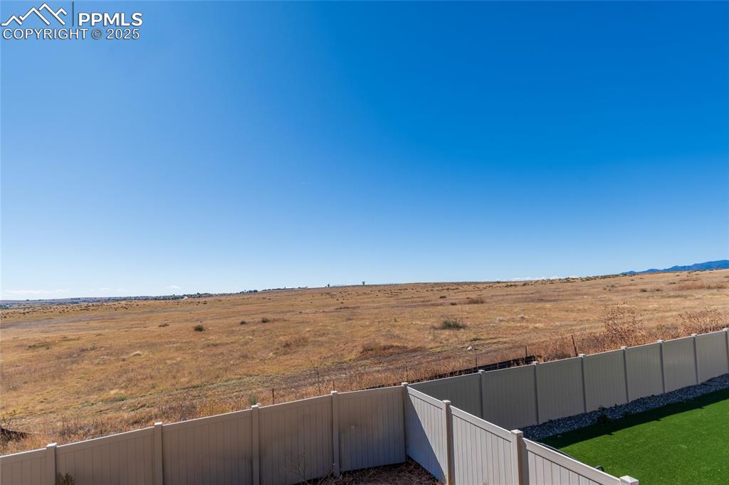 Image 10 of 46: Fenced backyard with a view of countryside