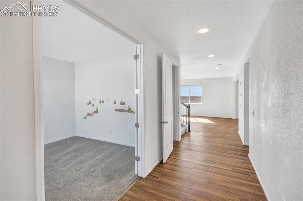 Image 11 of 46: Hallway featuring light wood-type flooring, recessed lighting, and a textur