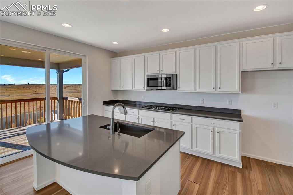 Image 18 of 46: Kitchen featuring white cabinets, light wood-style floors, recessed lightin