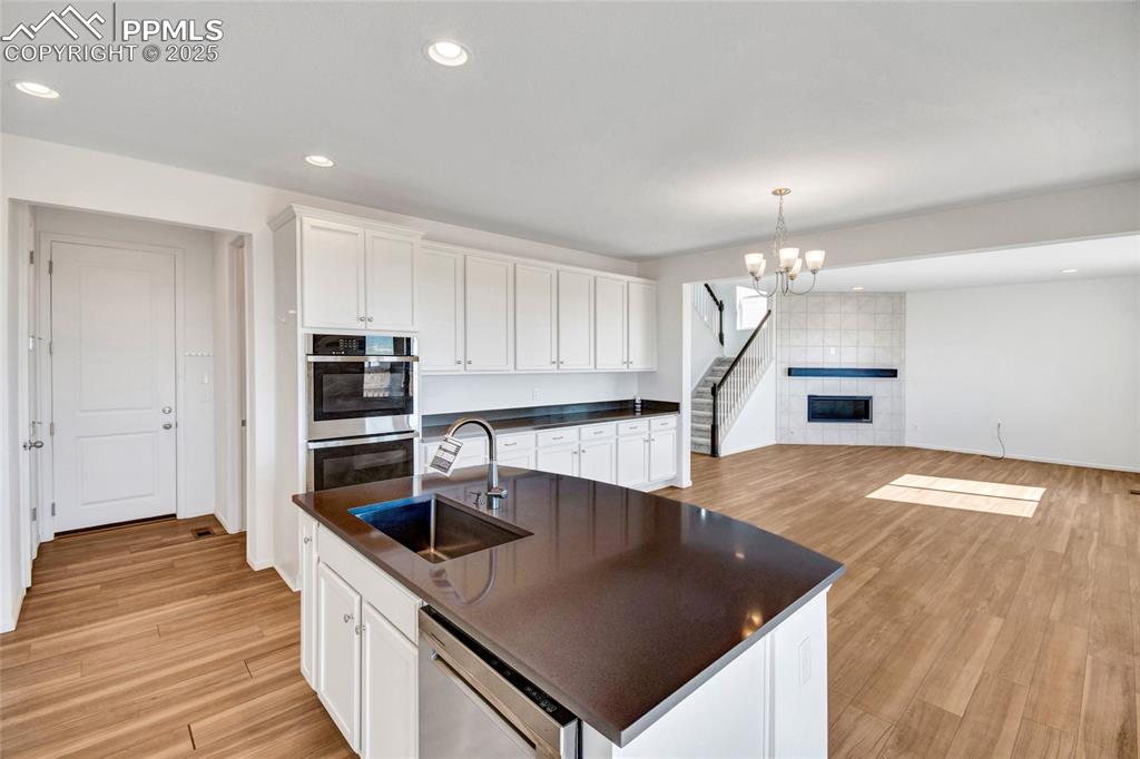 Image 20 of 46: Kitchen featuring white cabinets, recessed lighting, light wood-style floor
