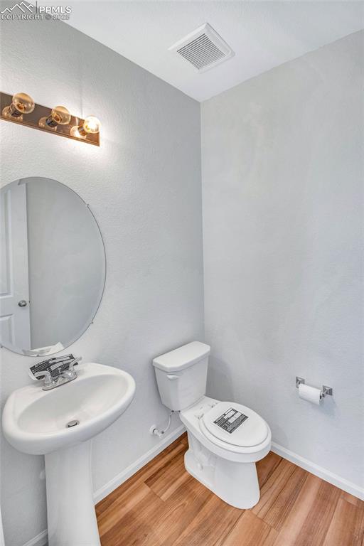 Image 21 of 46: Bathroom with wood finished floors and a textured wall