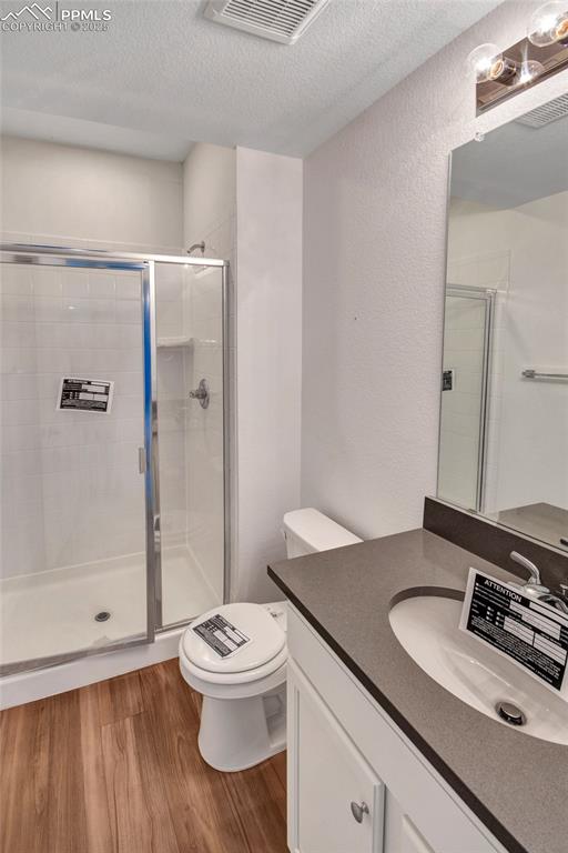 Image 22 of 46: Bathroom with light wood-style flooring, a textured ceiling, vanity, a show