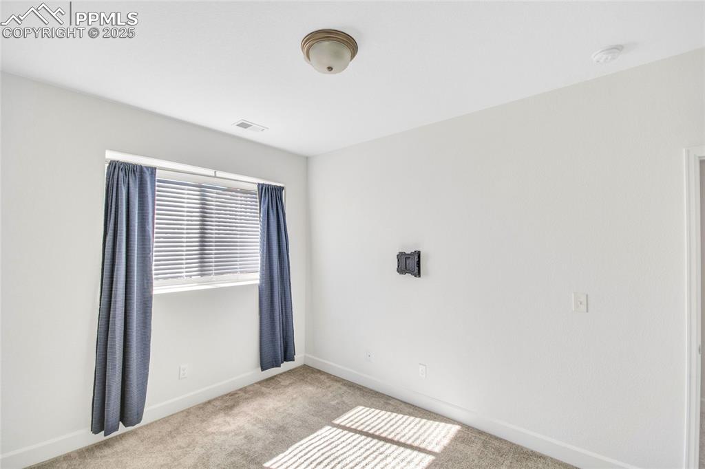 Image 23 of 46: Empty room featuring light carpet and baseboards