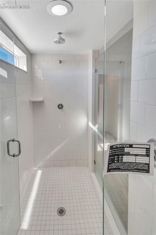 Image 35 of 46: Bathroom featuring a stall shower and a textured ceiling
