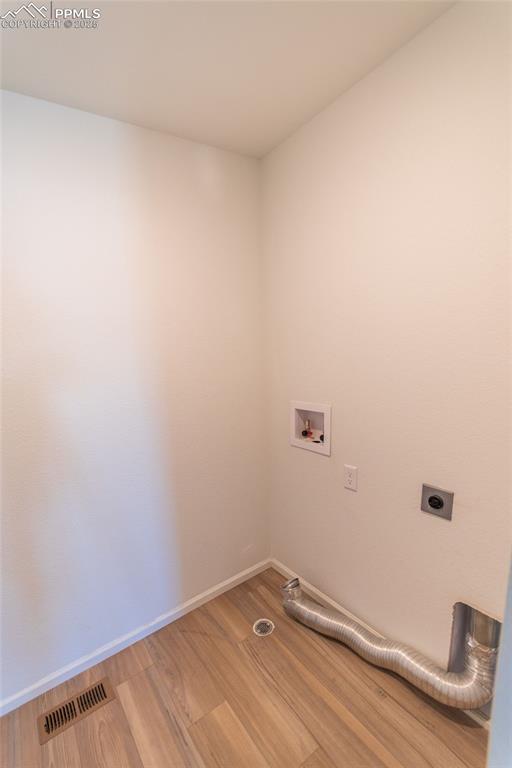 Image 44 of 46: Washroom featuring wood finished floors, hookup for a washing machine, and