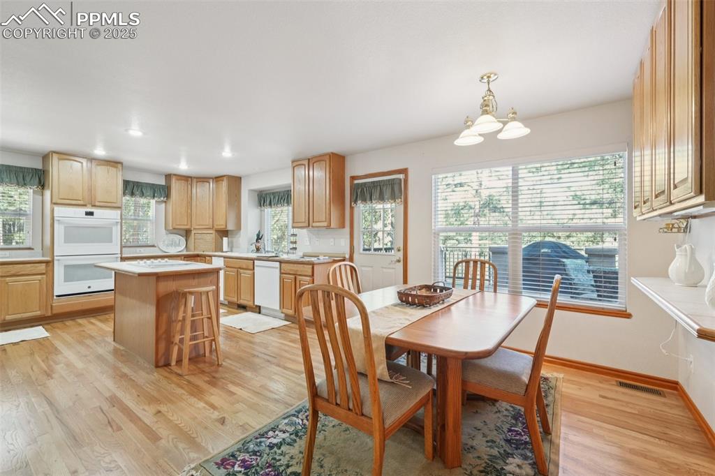 Image 16 of 45: Dining room with light wood-style floors and recessed lighting