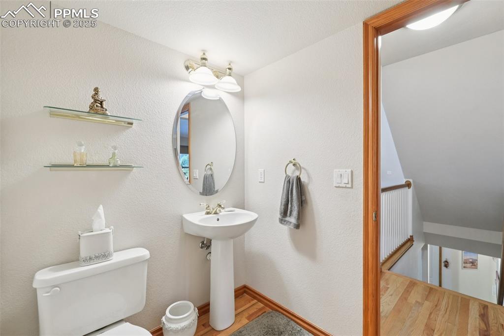 Image 22 of 45: Half bath featuring wood finished floors and a textured wall