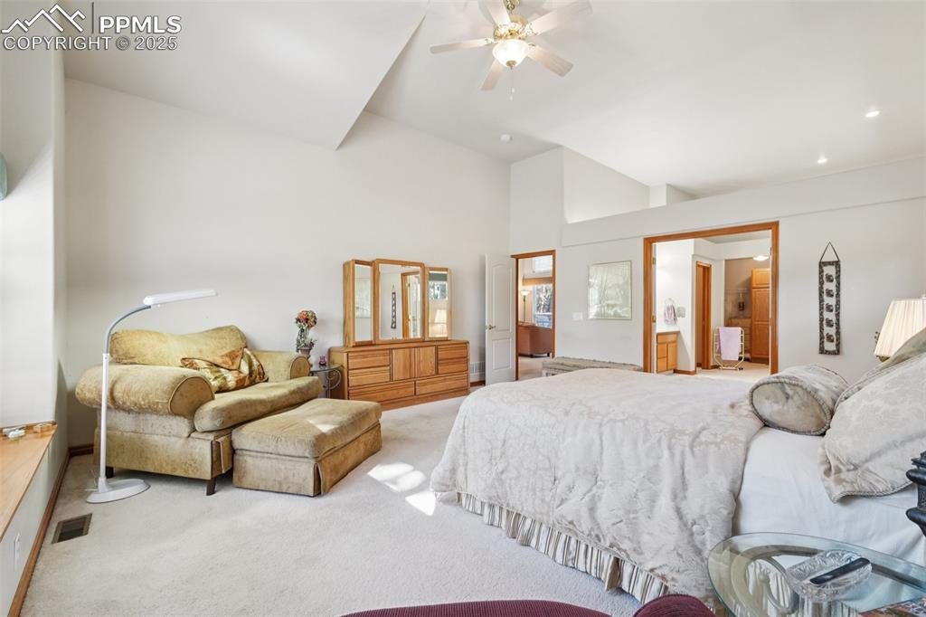 Image 25 of 45: Carpeted bedroom featuring a ceiling fan and a towering ceiling