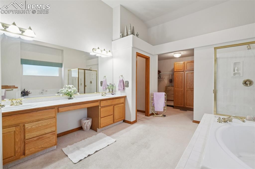 Image 26 of 45: Bathroom featuring double vanity, a shower stall, a garden tub, and a close